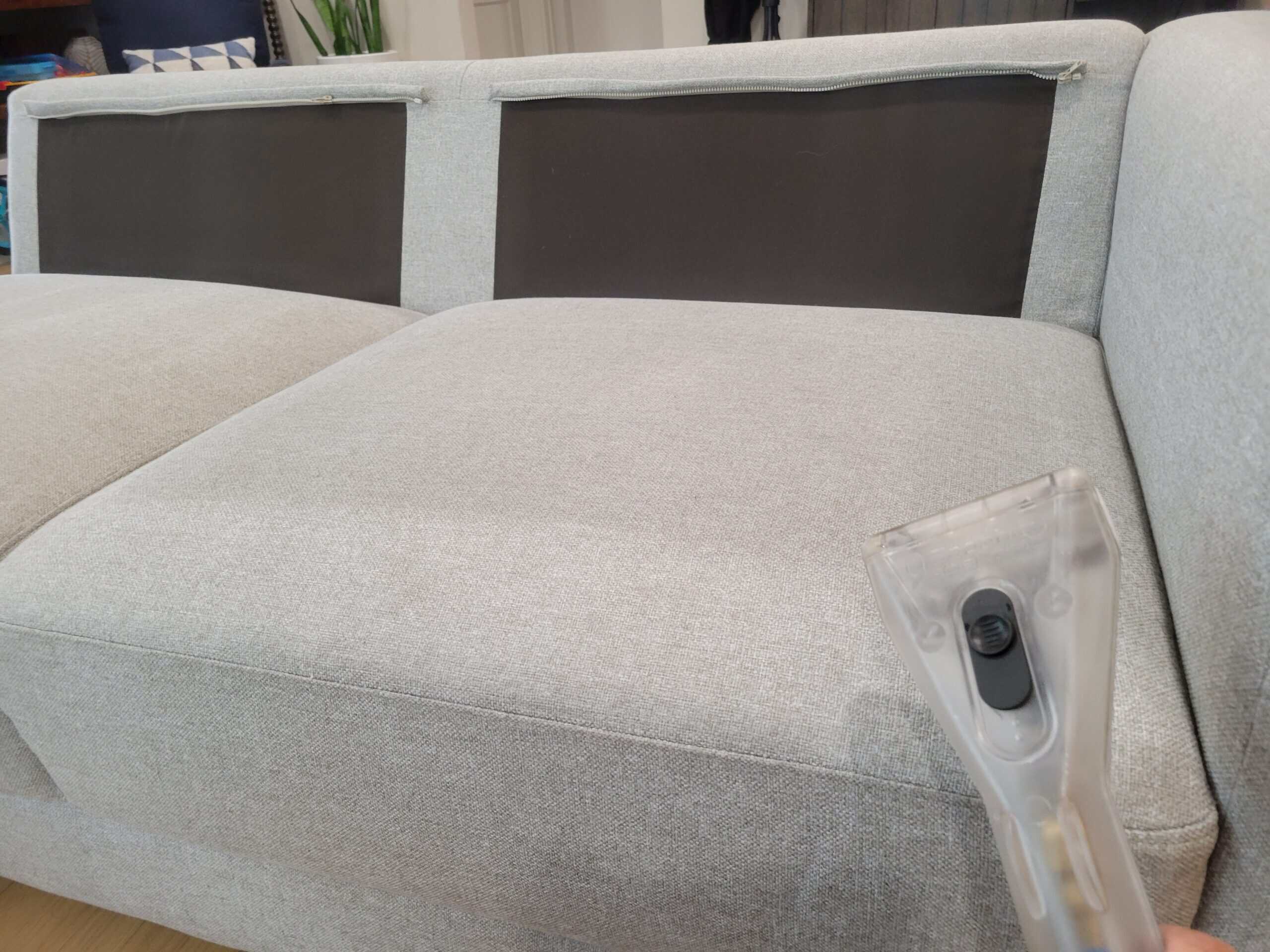 Upholstery cleaning technician treating a sofa cushion for a Las Cruces, NM customer